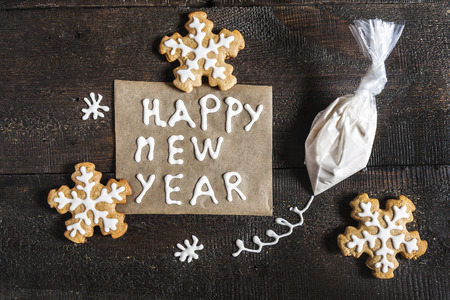Christmas gingerbread, inscription and a bag of icing sugar on a dark background.の写真素材