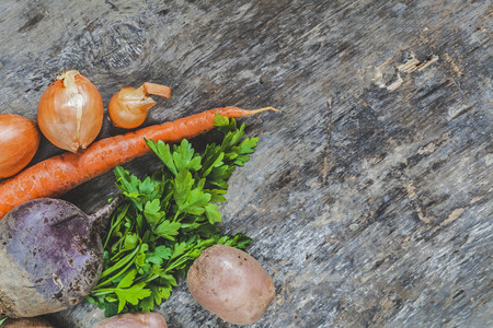potatoes, carrots, onions, parsley, beets raw on rustic background.の写真素材