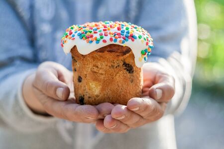 Womens hands hold decorated Easter cake, close-upの写真素材