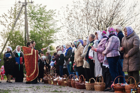 At Easter, the priest blesses the people with baskets and candles. Ukraina.Fastov. May 1, 2016.