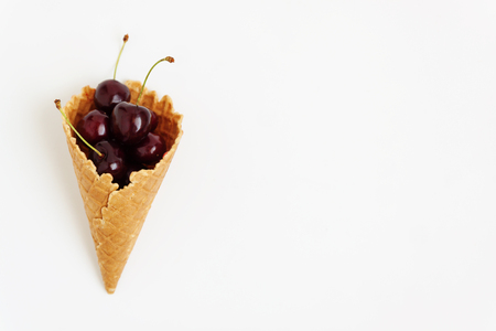 Waffle cone with fresh cherry berries, top view, isolated on white background.の写真素材