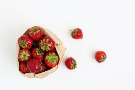 Fresh strawberries in a paper bag isolated on a white background. Concept of healthy and healthy nutrition.の写真素材