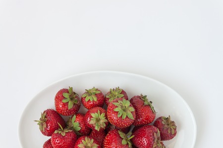 Fresh juicy strawberries on white plate, served with cutlery, isolated on white backgroundの写真素材