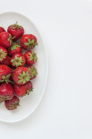 Fresh juicy strawberries on white plate, served with cutlery, isolated on white backgroundの写真素材