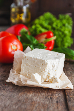 cheese feta-brynza and fresh vegetables, lettuce, tomato, cucumber, pepper on a wooden background in daylight.の写真素材
