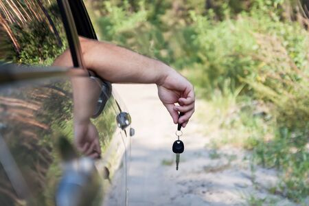 man's hand holds the keys to the car.