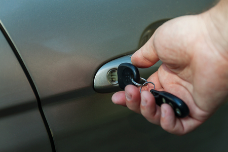 man's hand opens the car door with a key.の写真素材