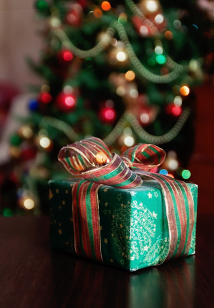 Gifts under the Christmas tree lights background.の写真素材