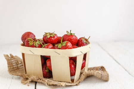 Delicious ripe strawberry in wooden basket isolated on white background.の写真素材