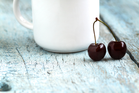 Cherries in the beautiful cup on wooden table, macro background, fruits, berries.の写真素材