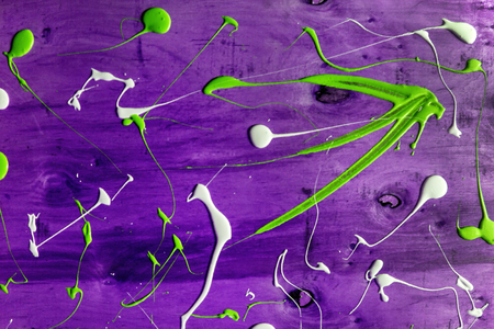 Artist working wooden table top with paint  marks spill all over the surface. Backgrounds collection - Blots and smudges of paint on the painted wooden wallの写真素材