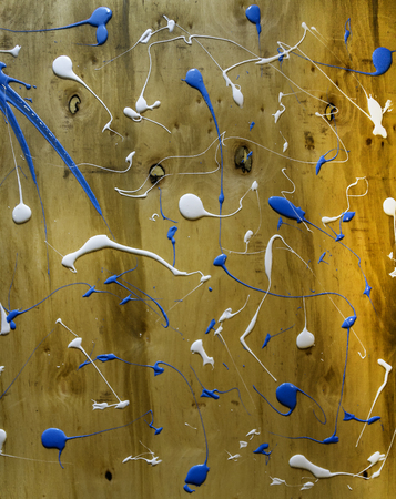 Artist working wooden table top with paint  marks spill all over the surface. Backgrounds collection - Blots and smudges of paint on the painted wooden wallの写真素材