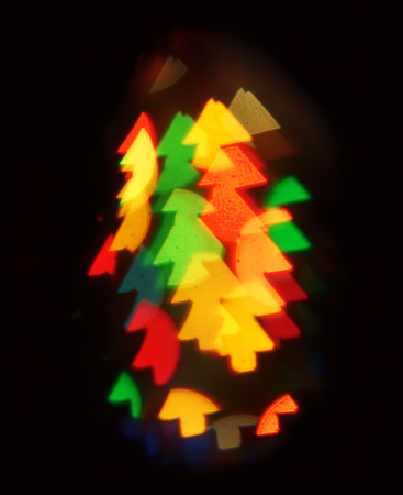 Background of blurred lights in the shape of Christmas trees on a dark. Copy space.の写真素材