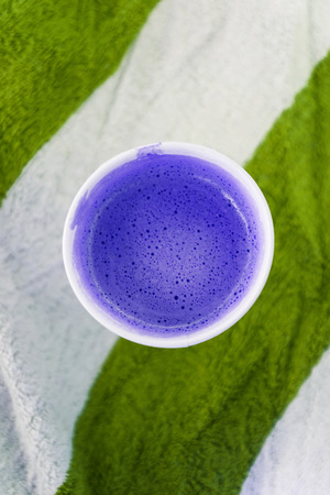 Glass with coffee on a striped beach towel. Abstract colors. Top view, copy space, flat lay.の写真素材