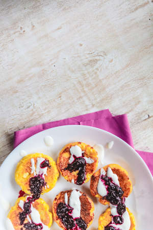 Curd cheese cakes, pancakes with sour cream and jam on a plate and a light background. Top viewの写真素材