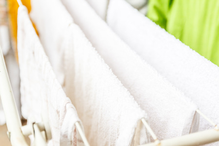 White and colored linen and towels to be dried on the clothesline.の写真素材