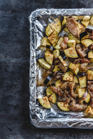 Baked chicken and eggplant on a dark background. Top viewの写真素材