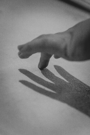 Hand and her shadow on the wall. Black and white. Monochrome.の写真素材