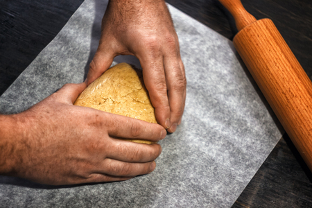 man's hands knead the dough in retro style on a dark background.の写真素材
