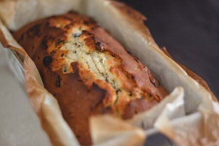 Rectangular ruddy metropolitan cake-bread in a metallic baking dish on a dark background. Close-up....