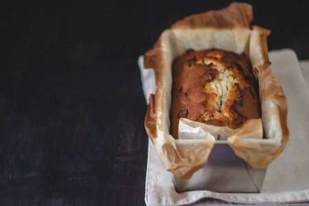 Rectangular ruddy metropolitan cake-bread in a metallic baking dish on a dark background. Close-up. View from above. Copy space.の写真素材