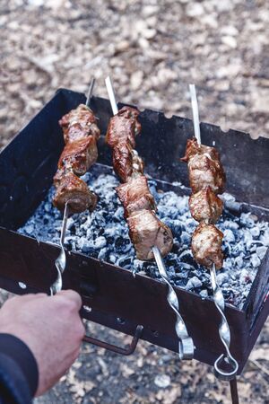man holds in his hands a skewer with raw meat, life style.の写真素材