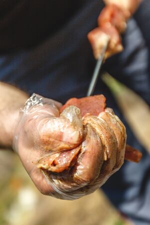 man stringing meat on a skewer. Close-upの写真素材