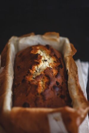 Rectangular ruddy metropolitan cake-bread in a metallic baking dish on a dark background. Close-up....