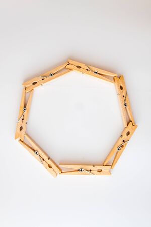 circle frame made of wooden clothes pegs on a white background. View from above. Copy space. The concept of naturalness and eco.の写真素材