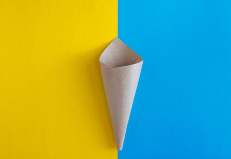 paper craft blank cone on blue and yellow background. top view. Flat lay, save space.の写真素材