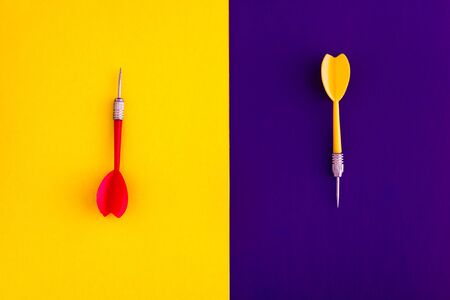 Multicolored red yellow green darts arrows on yellow violet blue background. Flat lay. View from...