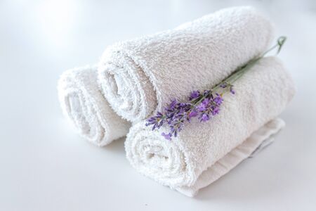 white clean towels and lavender flowers on white isolated backgroundの写真素材