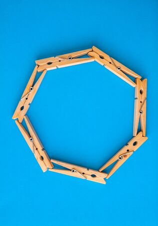 round or rectangular frame made of wooden clothespins on the blue background. Top view. Copy space. The concept of naturalness and eco.の写真素材