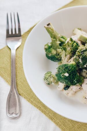 baked broccoli with chicken on a white plate. Top view, close-up. Healthy and proper nutritionの写真素材