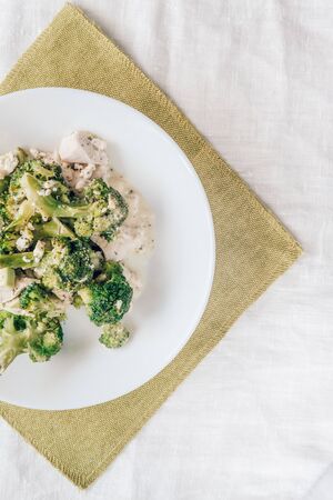 baked broccoli with chicken on a white plate. Top view, close-up. Healthy and proper nutritionの写真素材