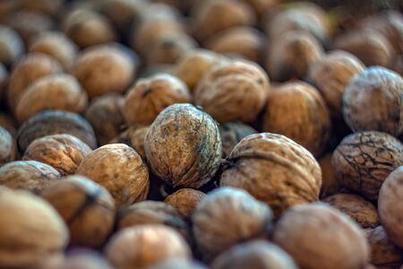 Natural walnut background pattern texture. Abstract walnuts heap pattern background Blurred edges frame Natural food in-shell nuts walnuts pattern backdrop Walnuts in shell background dramatic contrast.の写真素材