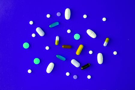 scattered various colored tablets in a blue-cyan background. View from above. close-up.の写真素材