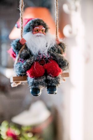 Santa Claus on a swing and skiing at the festive tree, Christmas toy, life style.の写真素材