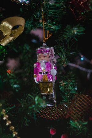 Christmas toys in the form of a ceramic antique nutcracker on a Christmas decorated Christmas tree....