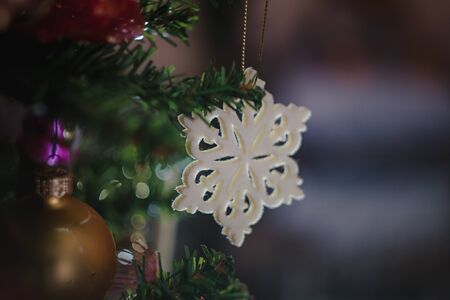 Christmas toys in the form of a blue-red-white vintage star-snowflake on a Christmas decorated Christmas tree. Close-upの写真素材