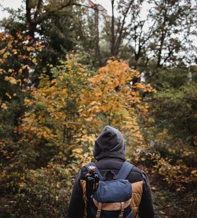 A young guy with a backpack in the hat, traveler, hipster standing in the woods, Hiking, Forest,Journey..の写真素材