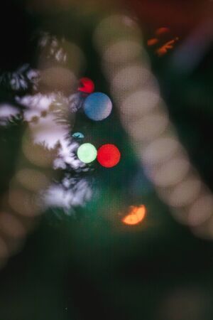 colored with lights a garland on a Christmas decorated tree in blur, bokeh. Close-upの写真素材