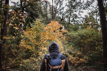 A young guy with a backpack in the hat, traveler, hipster standing in the woods, Hiking, Forest,Journey..の写真素材