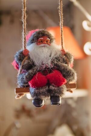 Santa Claus on a swing and skiing at the festive tree, Christmas toy, life style.の写真素材