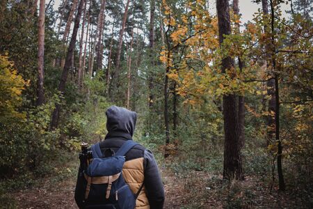 A young guy with a backpack in the hat, traveler, hipster standing in the woods, Hiking, Forest,Journey.の写真素材