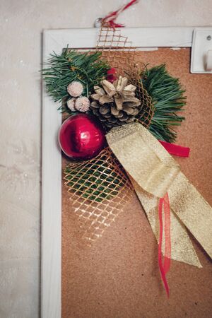 Christmas decor decoration from fir branches, balls and ribbons hanging on a home mudboard on a white backgroundの写真素材