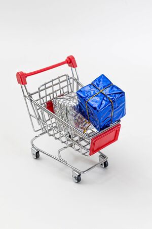 Grocery cart with New Year's holiday gifts on a white isolated plain background. Flat lay. Save the space. Postcard Template.の写真素材