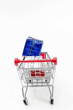 Grocery cart with New Year's holiday gifts on a white isolated plain background. Flat lay. Save the space. Postcard Template.の写真素材