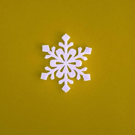 Christmas holidays composition, top view white snowflakes decoration on yellow background with copy space for text. Flat lay. Winter, postcard template.の写真素材