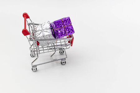 Grocery cart with New Year's holiday gifts on a white isolated plain background. Flat lay. Save the space. Postcard Template.の写真素材